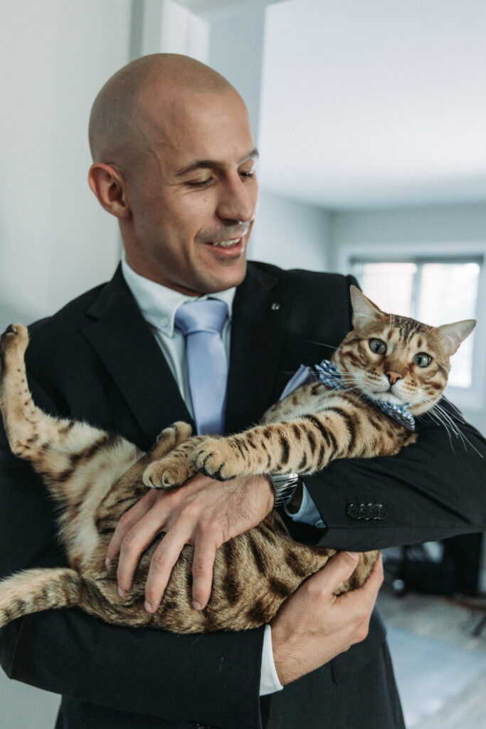 Candid Wedding Photography. Serbian Groom holding his prize possession his cat!